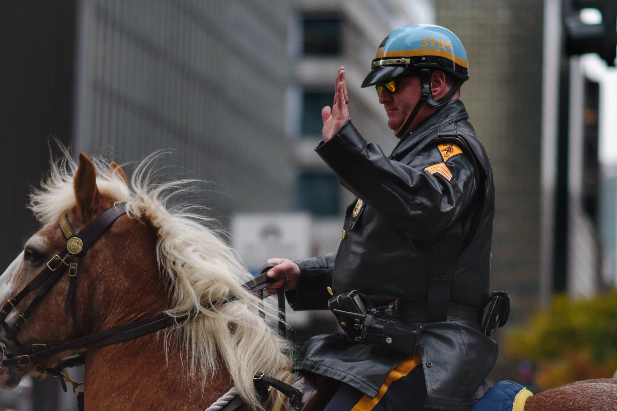 A mounted police officer acknowledges spectators along the route.